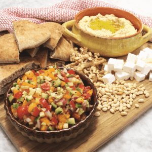 Classic hummus Board with hummus, marinated vegetables, nuts, feta, and pita